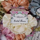 Noor Bridal Pearl & Silk Favors for bridal shower gift ideas, featuring ivory silk scrunchies with pearl bracelets and custom floral tags.