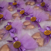 Heart Shower Favors with gold-wrapped chocolate hearts in purple mesh pouches, tied with bows and personalized gold tags for bridal showers.