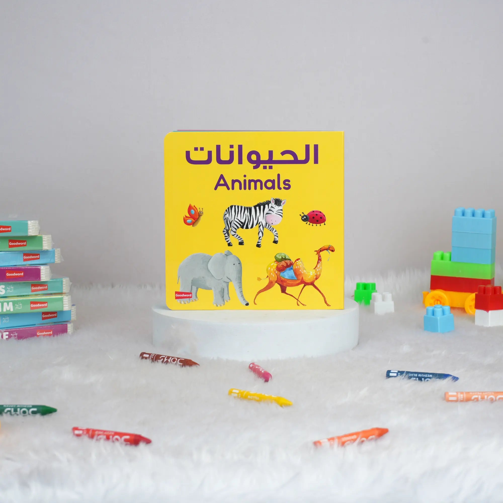 Children's book titled 'Animals' with colorful illustrations on a white surface with toys around.