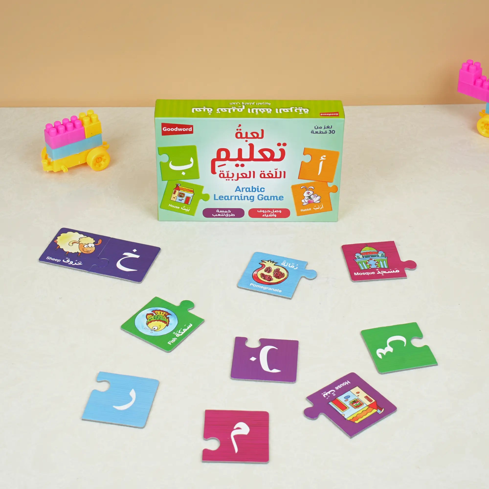 Arabic learning game set with colorful cards and a box on a white surface.