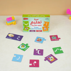 Arabic learning game set with colorful cards and a box on a white surface.