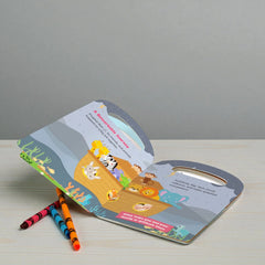 Children's book with crayons on a wooden surface and gray background