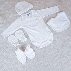 White baby outfit set with bodysuit, hat, bib, and booties on a light background