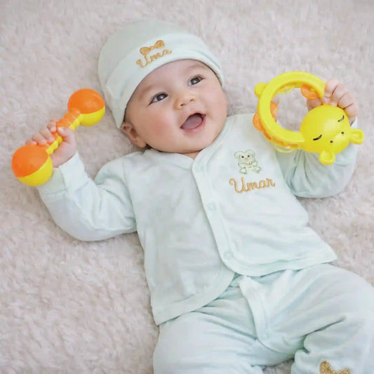 Personalized kids pyjama set for newborns in soft mint green with embroidered name 'Umar', includes matching cap, mittens, and bib for comfort.
