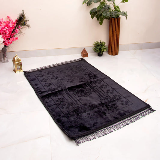 Black Janamaz with Name - Custom Black Prayer Rug laid out on marble floor, featuring intricate velvet texture and tassel edges, ideal for gifting.