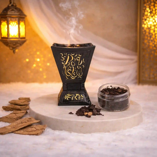 Black Majesty Bakhoor Burner with intricate gold detailing, placed on a marble tray with bakhoor and wood chips, ideal for Ramadan & EID home decor.