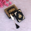 Black Stones Mini Tilawat-e-Quran with gold Arabic calligraphy, velvet cover, and decorative box. Includes elegant feather tassel bookmark.
