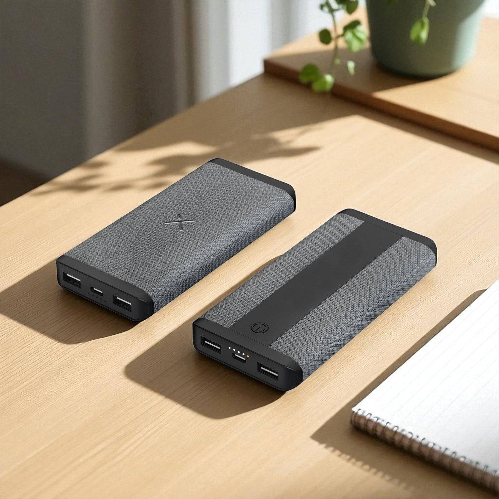 Two black power banks on a wooden surface