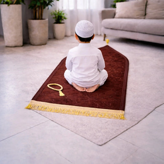 Brown Kids Dome Janamaz - Kids Prayer Rug in use by child in white attire, soft and foldable, ideal for home prayer setting.