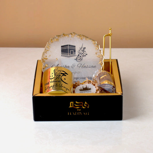 Pilgrim's Promise Hamper - Hajj Gift Hamper with personalized candle, Kaaba-themed frame, and chocolates in a luxury black and gold box.