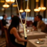 Gold Bar Pendant Necklace engraved with 'Love Forever' in a romantic restaurant setting, ideal personalized gift for anniversaries or birthdays.