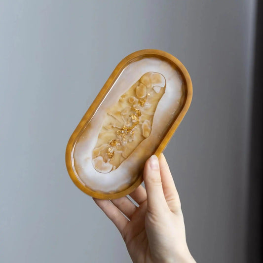 Handcrafted gold flakes resin trinket tray used as a jewelry organizer.