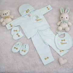 Personalized kids pyjama set in pastel blue with embroidered name 'Umar', includes cap, mittens, bib, and booties, ideal for newborn comfort and style.