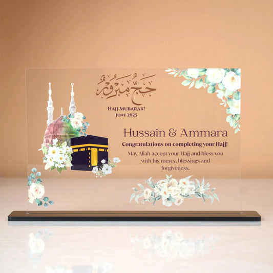 Labbaik-e-Haram Gifting Plaque featuring Kaaba and Masjid Nabawi illustrations with floral accents, ideal for Hajj or Umrah return gifts or keepsakes.