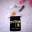 Tasleem Gift Set - Hajj Umrah Return Favours with velvet pouch, Ajwa dates, Zamzam water, attar, Tasbeeh, and chocolate on white fur background.