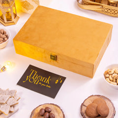 Golden Indulgence Hamper closed in a premium golden box with a thank you card, surrounded by festive dry fruits and sweets.