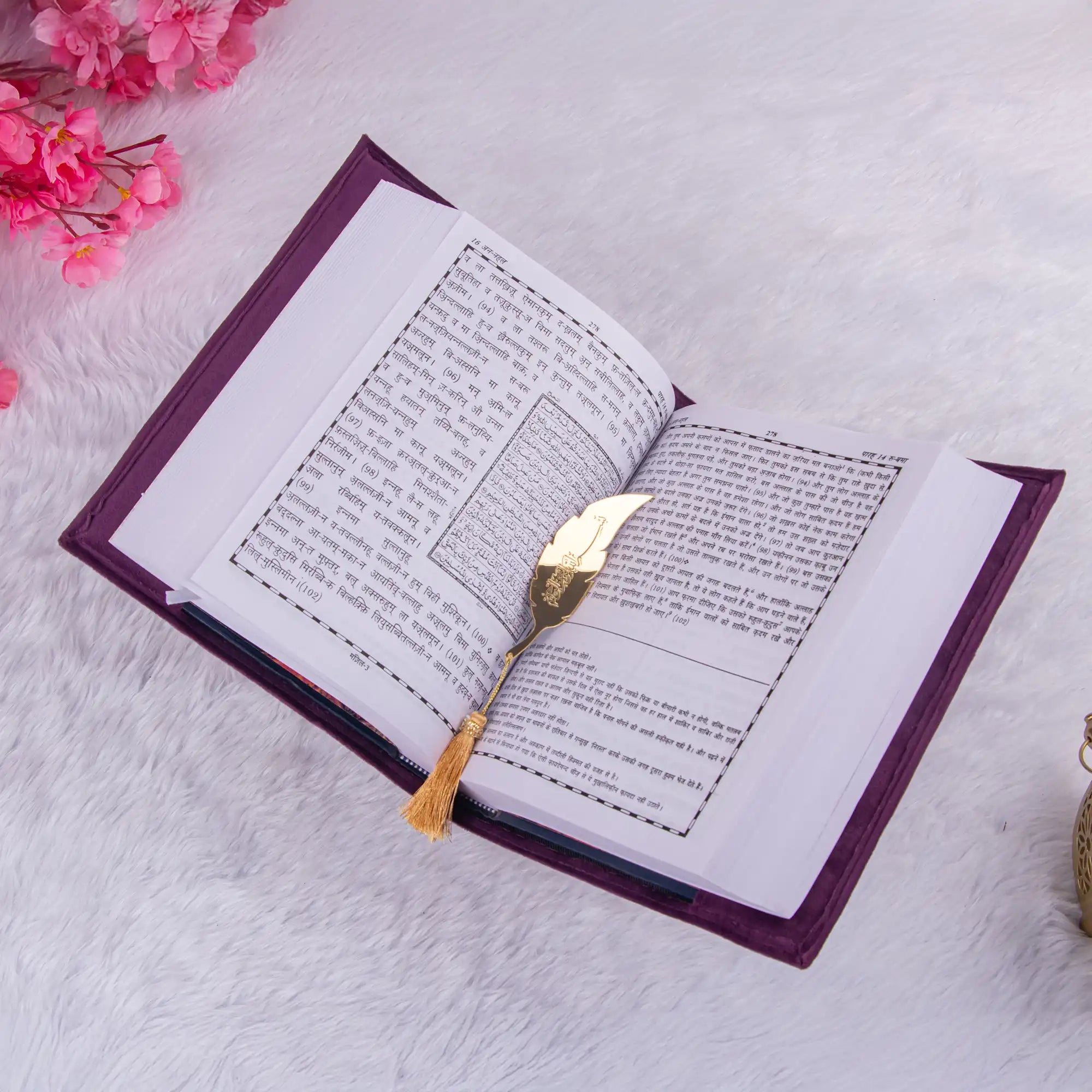 Open Velvet Quran Translation in purple with Urdu-Arabic text and gold feather bookmark, elegant gift for religious occasions.