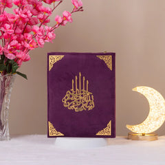 Premium velvet Quran from the Customised Purple Salah Combo Hamper displayed upright beside a crescent lamp and floral decor.