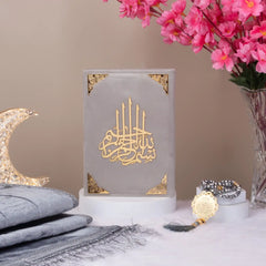 Premium Grey Salah Combo Hamper with velvet Quran, crystal Tasbeeh, and Janamaz displayed beside pink flowers and crescent decor.