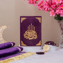 Customised Purple Salah Combo Hamper with premium velvet Quran, prayer mat, and tasbeeh displayed near pink blossoms and crescent decor.