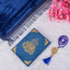 Blue祈祷毯 with gold embroidery on a white surface with pink flowers and a blue tassel.