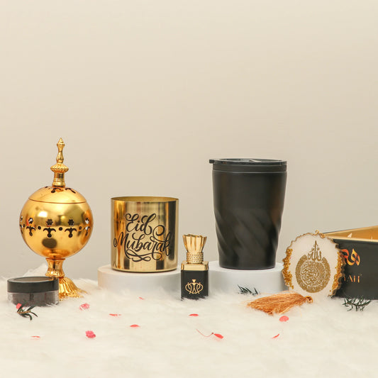 Eid Set for Husband - Eid Gift Set featuring gold bakhoor burner, Eid Mubarak candle, black travel mug, and perfume on white display.