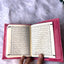 Open book with text held by a hand on a fluffy white surface