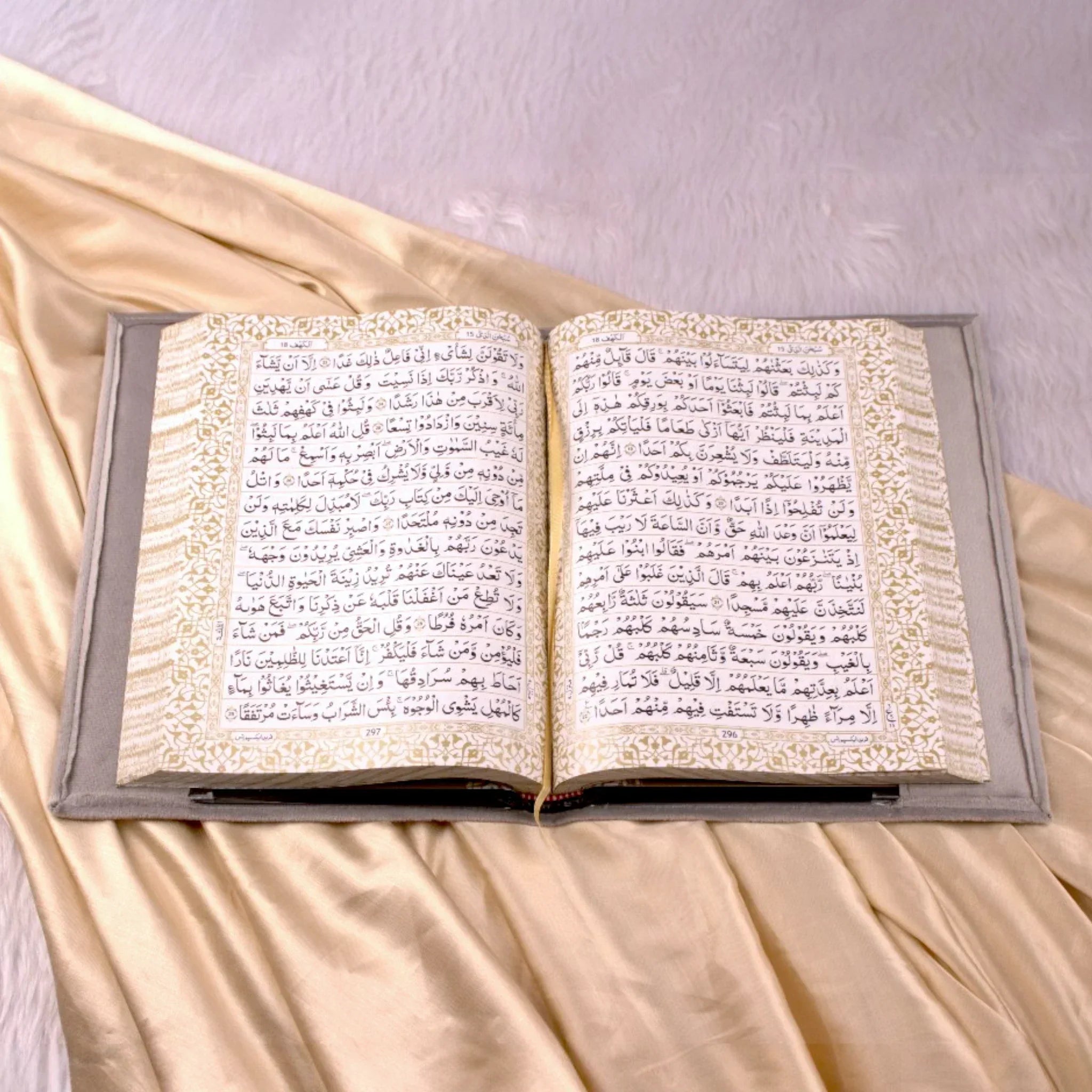 Open Holy Quran with ornate golden border and grey velvet cover from the Velvet Quran Rehal Hamper. Luxurious Islamic gift for special occasions.