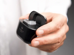 Zikr Ring with 99 Zirconia placed in black charging pod. Smart Islamic ring with charging case for continuous tasbeeh tracking.