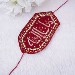 Decorative red and gold embroidered patch on a white fabric background