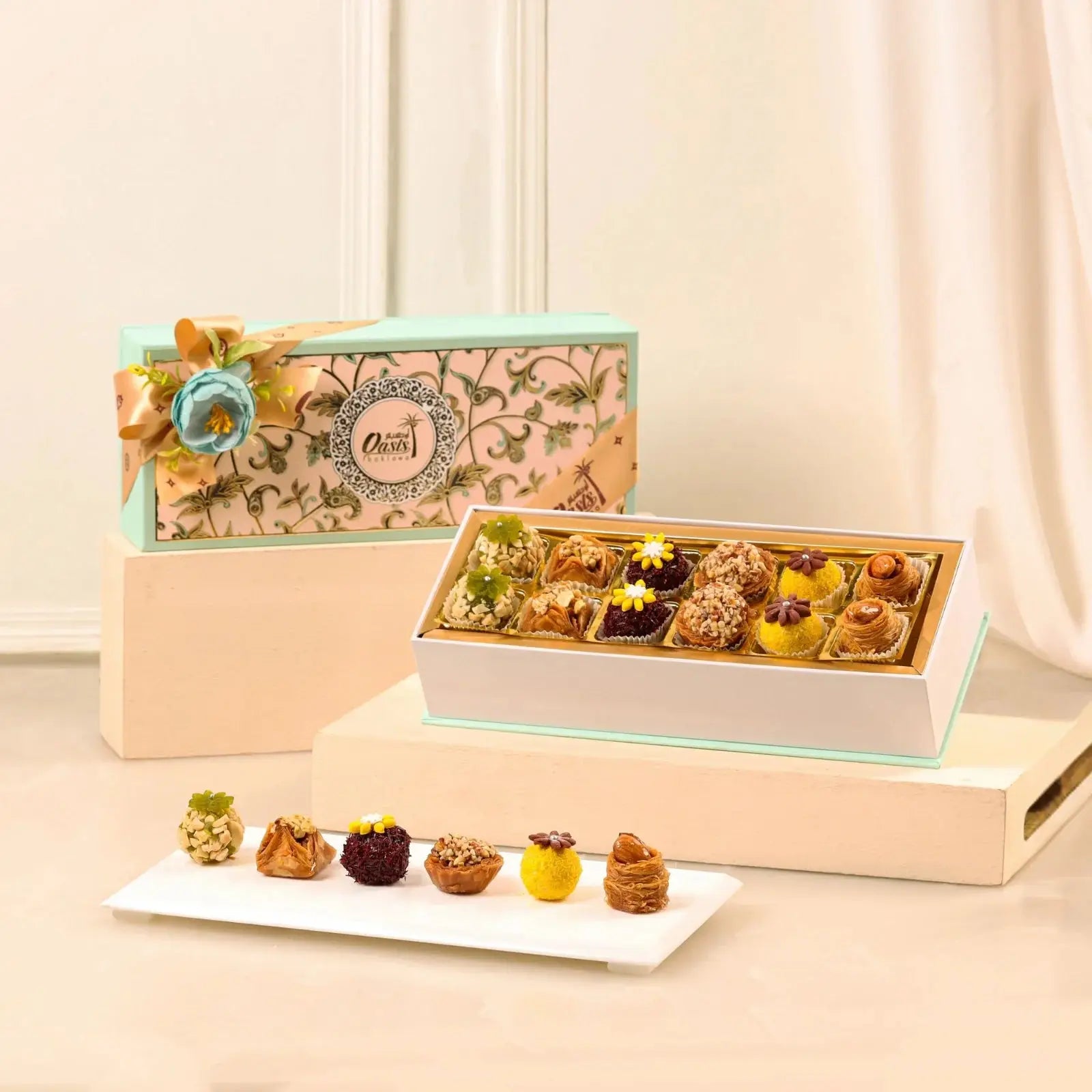 Assorted pastries in a decorative box with a floral design on a light background