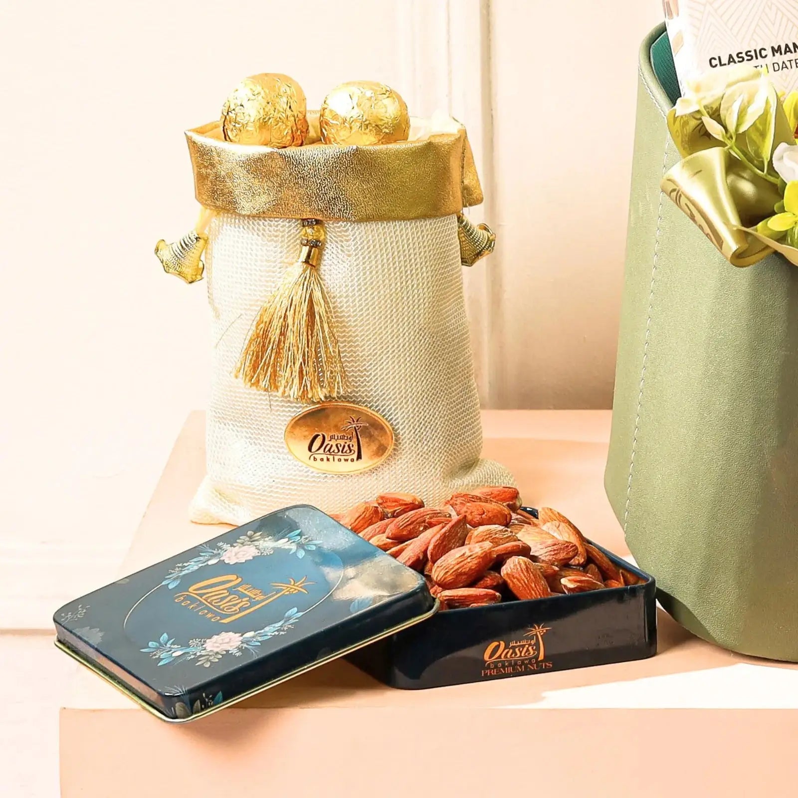 Decorative items including a gold and white bag, a tin box, and a container of nuts on a light surface.
