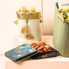 Decorative items including a gold and white bag, a tin box, and a container of nuts on a light surface.