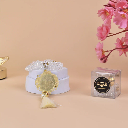 White Crystal Tasbeeh with 100 beads and gold Bismillah charm displayed on a white box, ideal Islamic gift for prayer and special occasions.