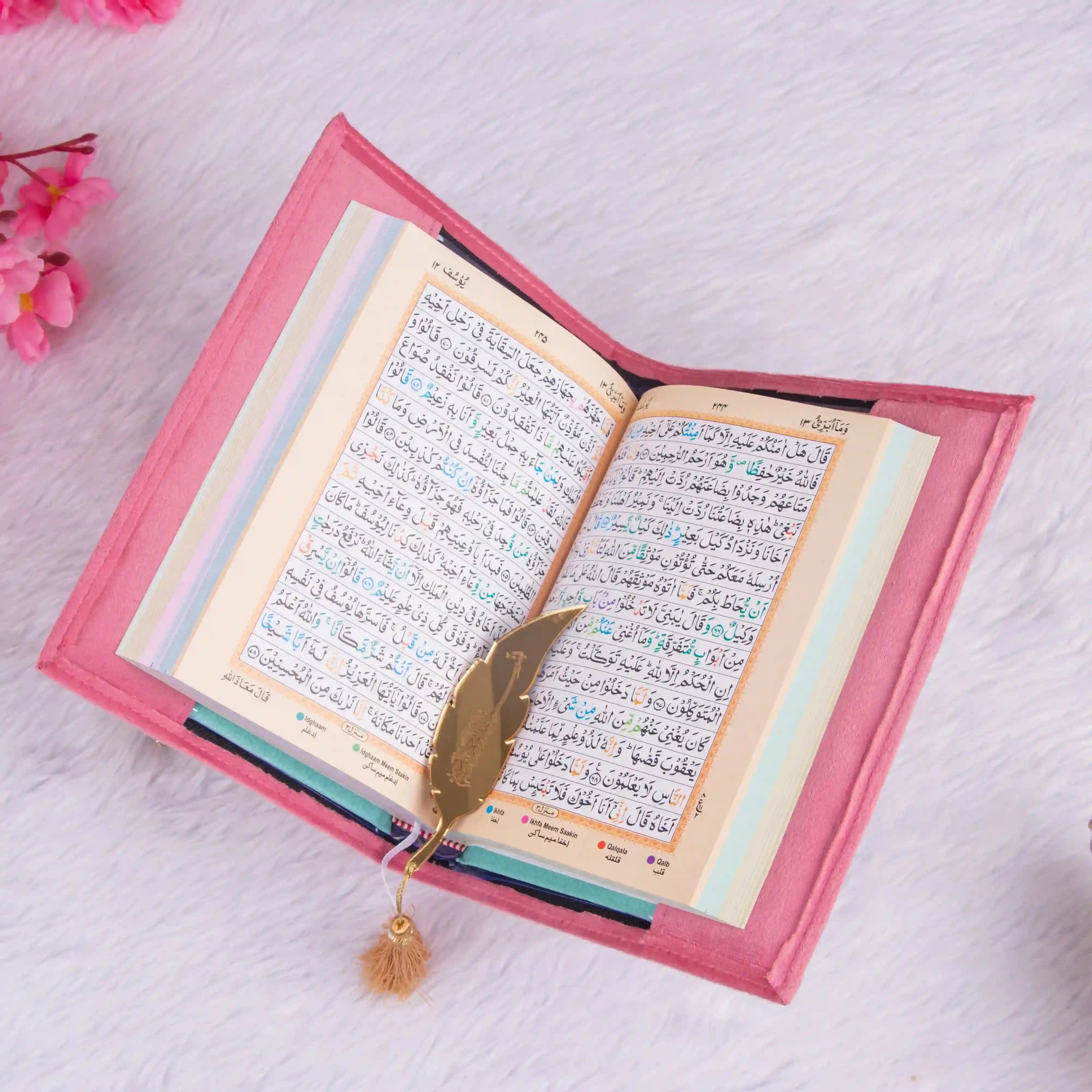 Open pink velvet Quran with Arabic script and golden feather bookmark, part of the Butterfly Quran Gift Set - Pink Butterfly Sawab-e-Jariya.
