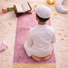Kids Dome Janamaz - Perfect Prayer Rug for Kids in pink with gold tassels, shown in use by a child during prayer on a soft carpeted floor.