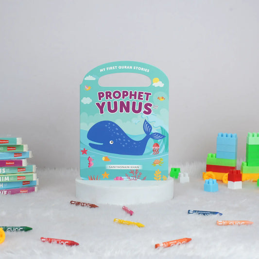 Children's book titled 'Prophet Yunus' with building blocks and crayons on a white surface