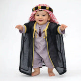 Baby boy wearing Purple Omani Thobe Romper & black Bisht Set with red and white keffiyeh. Shop our Purple Omani Thobe Romper & Bisht Set for Baby Boys.