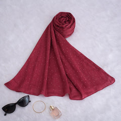Flat lay of Red Studded Hijab with accessories, highlighting soft polyester texture and studded design for chic modest fashion looks.