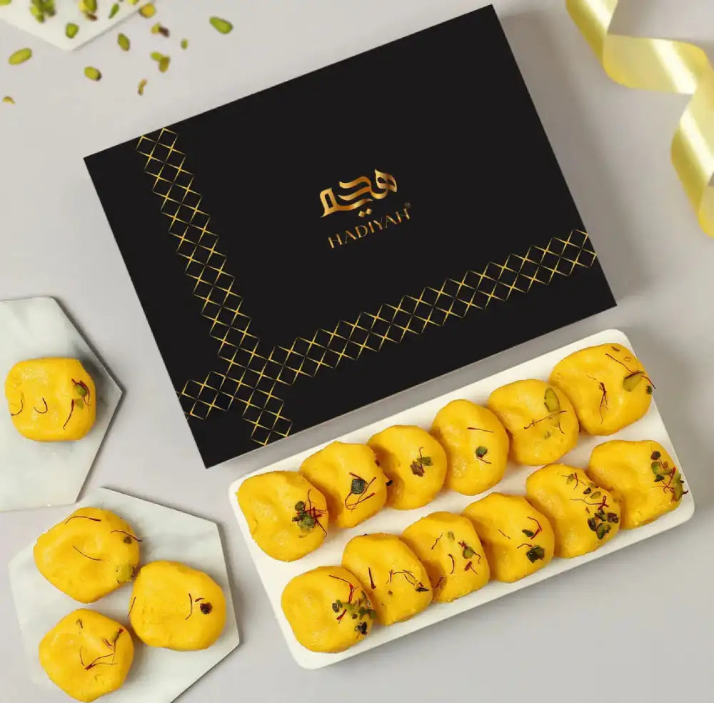 Tempting Mathura Peda - Indian Sweets | 200g & 400g, rich yellow khoya sweets garnished with pistachios, elegantly packed in a black gift box.