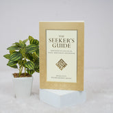 Book titled 'The Seeker's Guide' with a plant on a light background