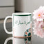 Umrah Mubarak Floral Mug with Arabic script and geometric floral design, 350 ml ceramic drinkware ideal for Umrah return gifts.