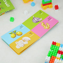 Colorful educational book with vegetable illustrations on a white surface with building blocks.
