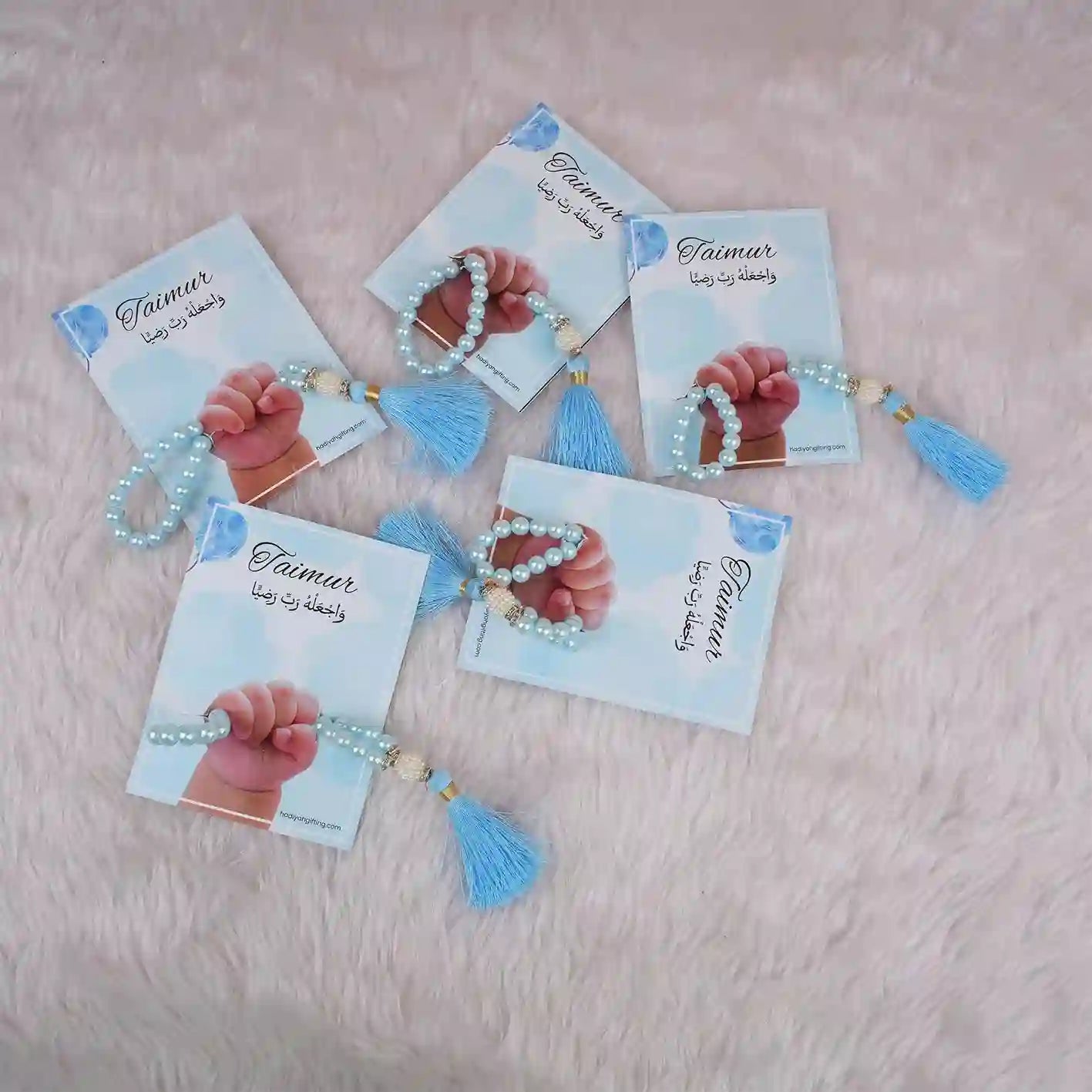 Five blue Little Hands Tasbeeh Keepsakes with personalized cards, ideal for Aqiqah gifting and religious ceremonies.