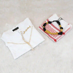 White garment with embroidery and a folded towel with a decorative pattern on a light surface