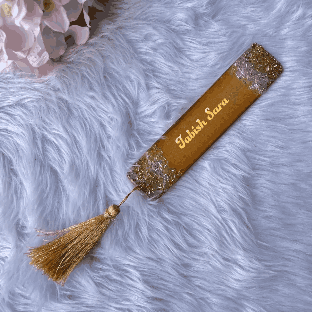 Golden resin Islamic bookmark with name 'Tabish Sara' and gold tassel, ideal for personalized wedding favors and spiritual book accessories.