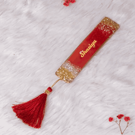 Red and gold personalized bookmark with 'Shaaiya' name and tassel, designed for Islamic wedding favors or custom book accessories.