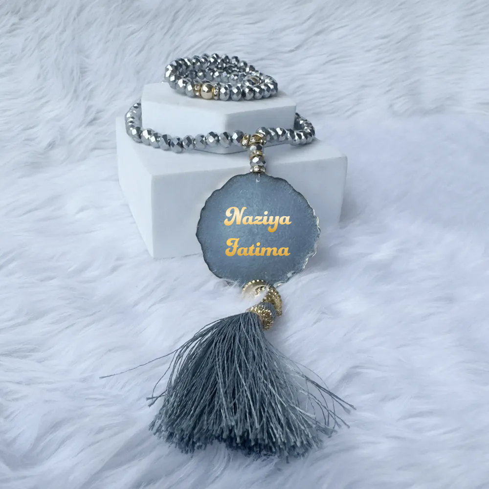 Grey Sequence Sawab-E-Jariya Hamper - Premium Quran Gift Set Online featuring personalized crystal Tasbeeh with name tag and grey tassel on white fur.