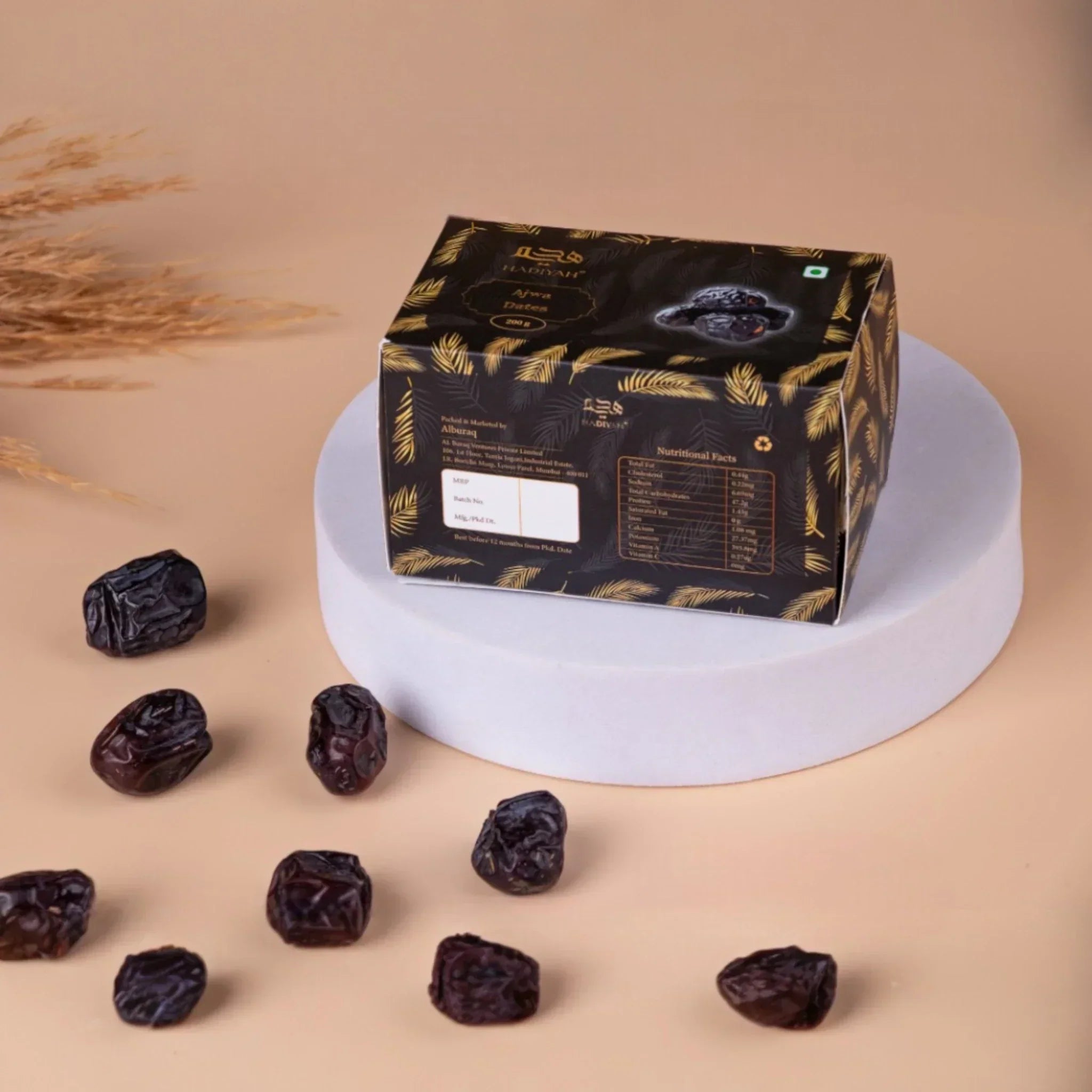 Premium Ajwa dates gift box with scattered dates on neutral background