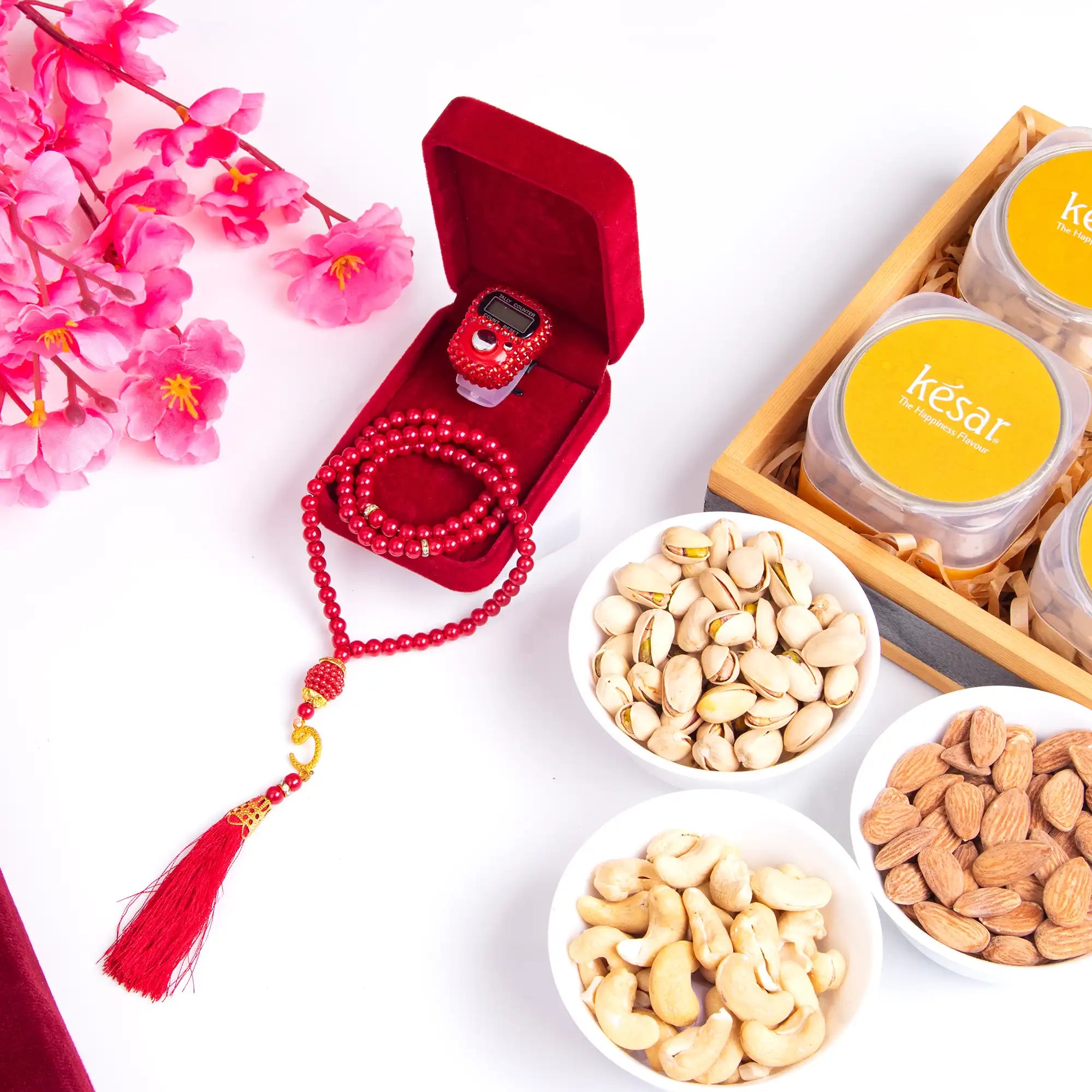 Ramadan gift hamper with tasbih, digital counter, nuts, and sweets.